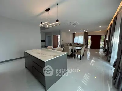 Spacious modern living room with elegant dining area and stylish lighting fixtures.