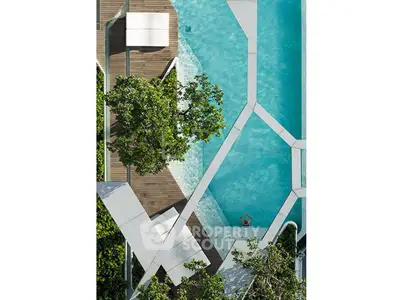 Stunning aerial view of modern pool with geometric design and lush greenery.