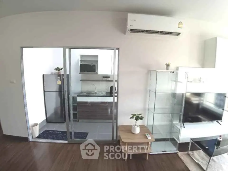 Modern apartment interior with open kitchen and living area featuring sleek appliances and stylish decor.