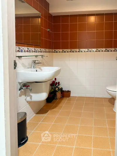 Charming bathroom with warm tiles and modern fixtures, perfect for relaxation.