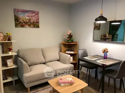 Cozy living room with modern decor, featuring a comfortable sofa and stylish dining area.