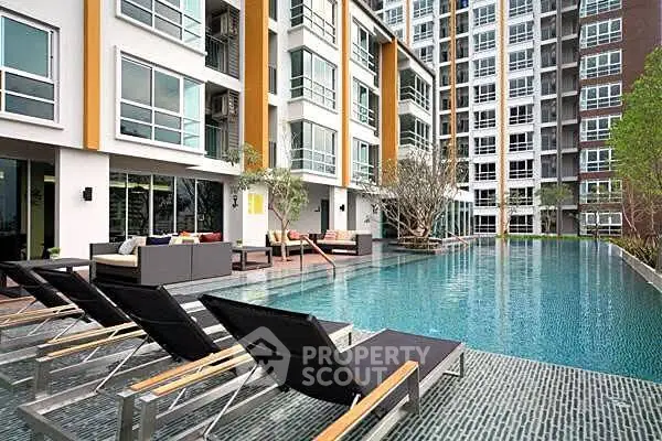 Modern apartment complex with luxurious pool and stylish outdoor seating area.
