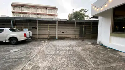Spacious parking area with adjacent building, ideal for commercial use.