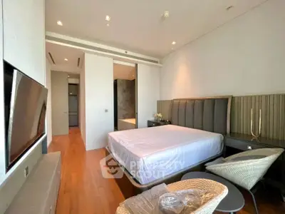 Luxurious bedroom with modern furnishings and sleek design, featuring a large bed and flat-screen TV.