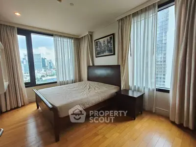 Spacious bedroom with city view and elegant wooden flooring