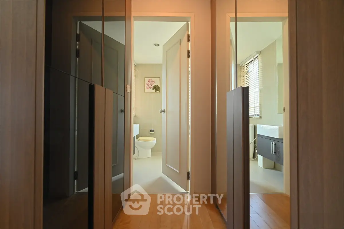 Modern bathroom with sleek design and wooden accents, featuring a spacious layout and natural lighting.