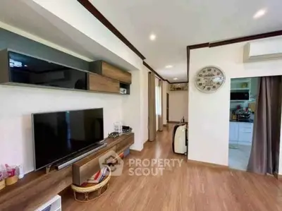 Modern living room with wooden flooring and sleek TV setup