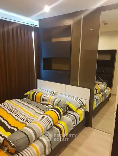 Modern bedroom with stylish decor and large mirror wardrobe