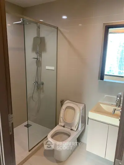 Modern bathroom with glass shower and sleek fixtures in a contemporary apartment.