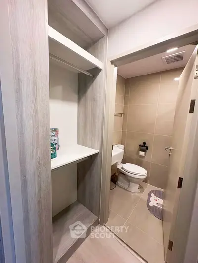Compact bathroom with modern fixtures and adjacent storage space in a contemporary apartment.