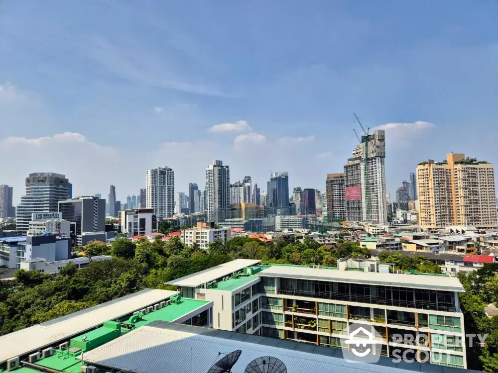 Stunning cityscape view from high-rise building balcony with lush greenery and modern skyline.