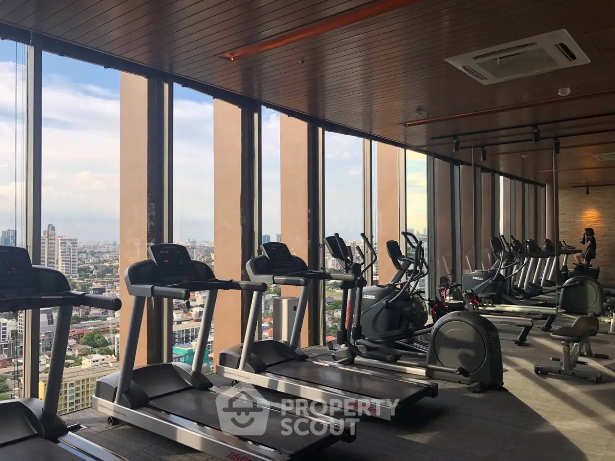 Luxurious high-rise gym with panoramic city views and modern fitness equipment.