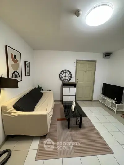 Cozy living room with modern decor, comfortable sofa, and sleek TV setup.