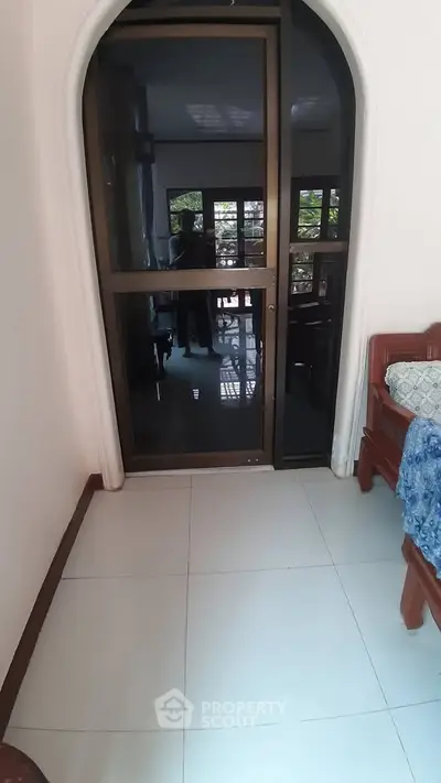 Cozy bedroom with arched window and tiled flooring
