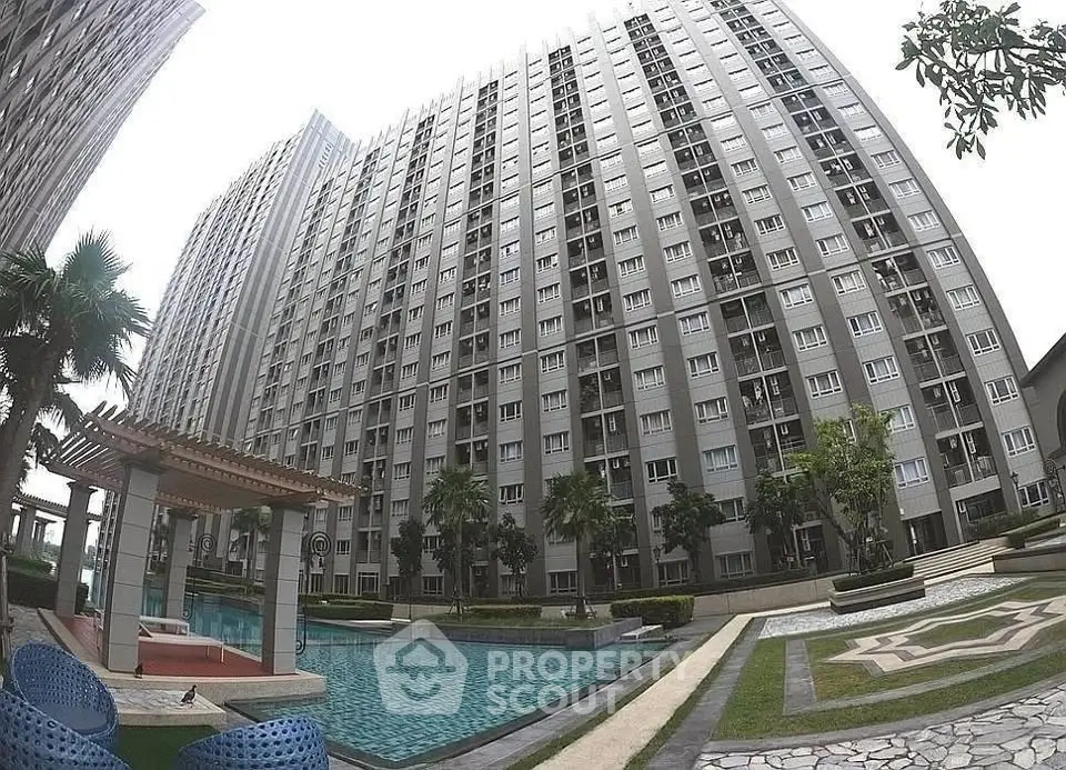 Modern high-rise apartment building with pool and landscaped garden area.