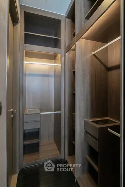 Luxurious walk-in closet with elegant wood finish and ample storage space.