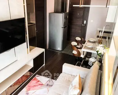 Modern open-plan living room with stylish kitchen and dining area, featuring sleek furniture and contemporary decor.