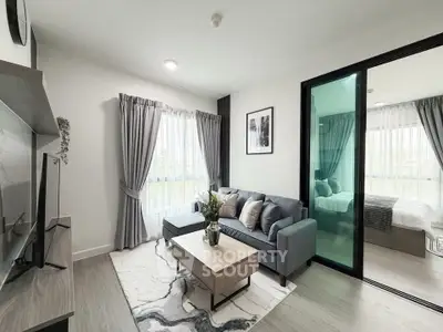 Modern living room with stylish decor and natural light, featuring a cozy sofa and elegant curtains.