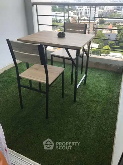Charming balcony with artificial grass and modern outdoor furniture offering a scenic city view.
