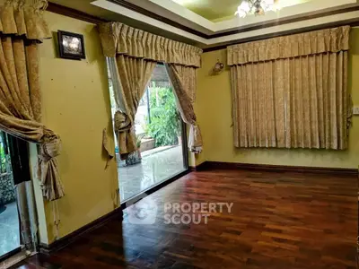 Spacious living room with elegant curtains and wooden flooring