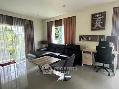 Modern living room with sleek furniture and large windows overlooking a garden.