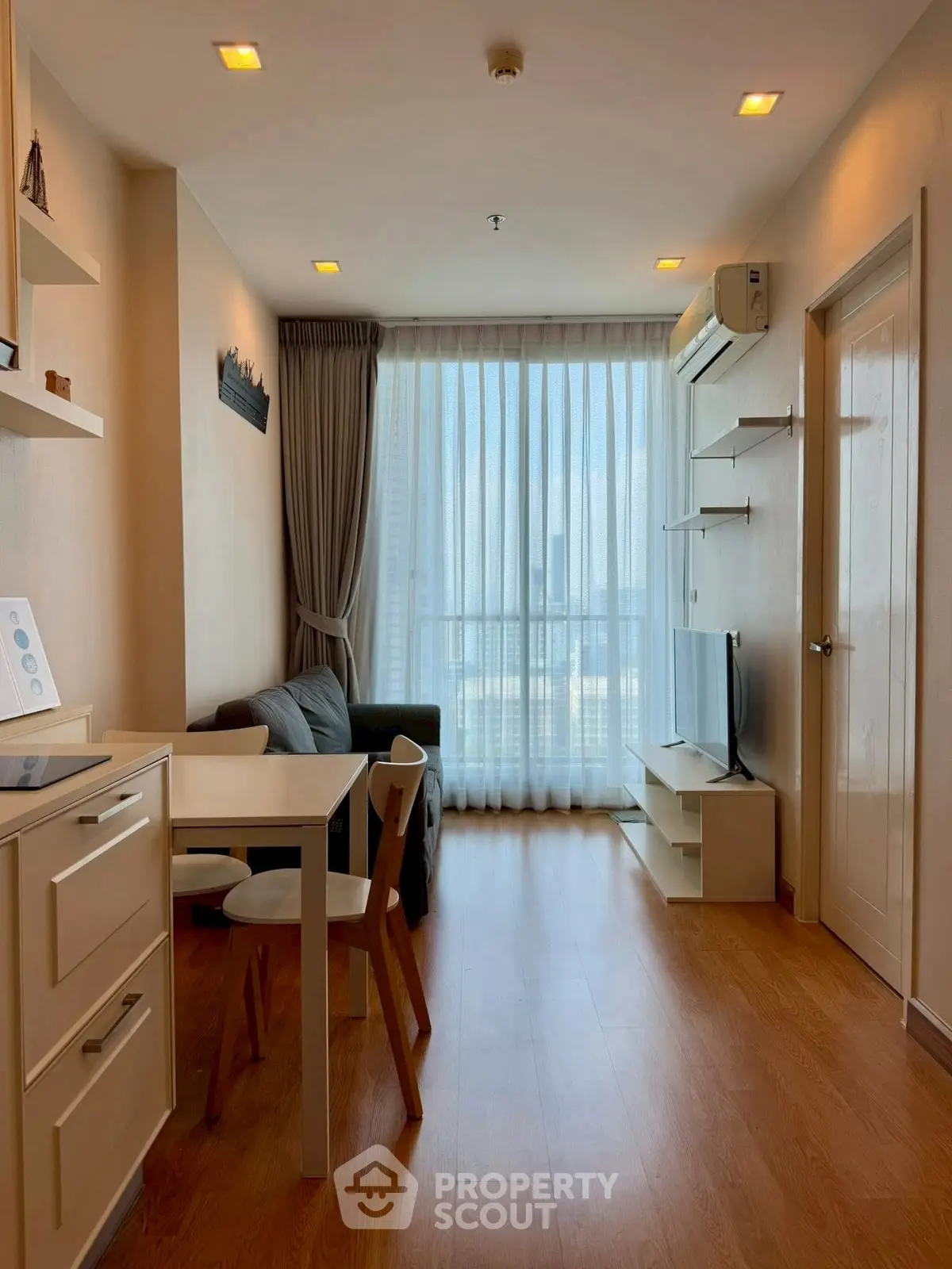 Modern living room with natural light, cozy seating, and sleek furniture in a stylish apartment.