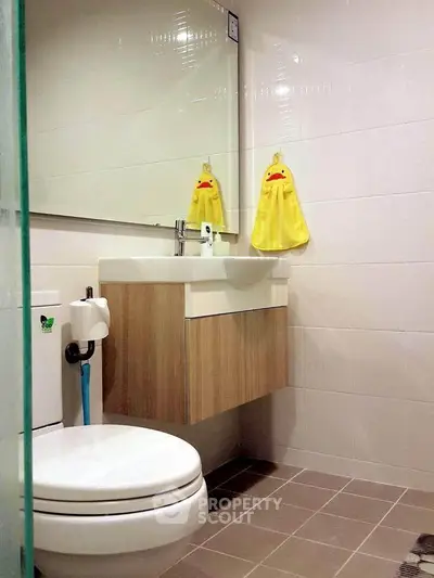 Modern bathroom with sleek fixtures and playful duck-themed towels, perfect for a cozy home.