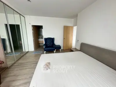 Spacious bedroom with modern decor and large mirrored wardrobe in a stylish apartment.