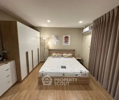 Modern bedroom with stylish decor, wooden flooring, and ample storage space.