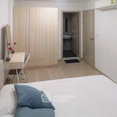 Cozy bedroom with modern furniture and ensuite bathroom in a stylish apartment.