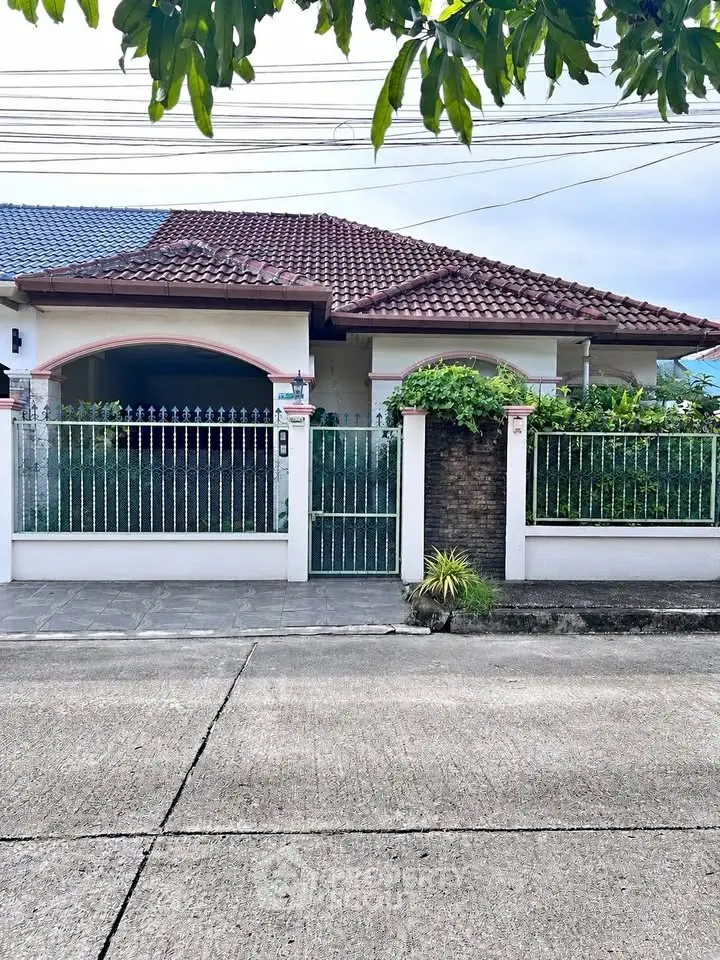 Charming suburban house with red-tiled roof and lush greenery, perfect for family living.