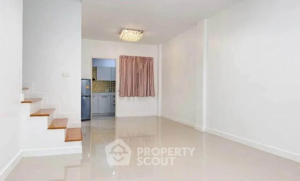 Spacious modern living room with staircase and open kitchen layout