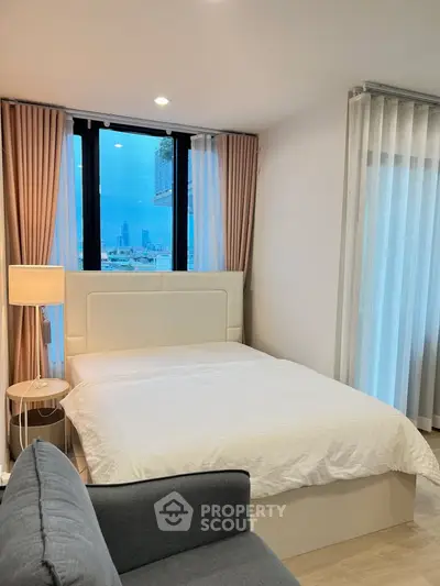 Modern bedroom with city view, featuring elegant decor and natural light.