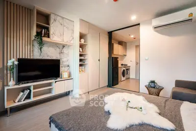 Modern living room with stylish decor and open layout, featuring a cozy seating area and sleek entertainment center.