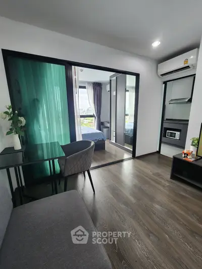 Modern apartment interior with open layout, featuring a cozy living area and a view into the bedroom.