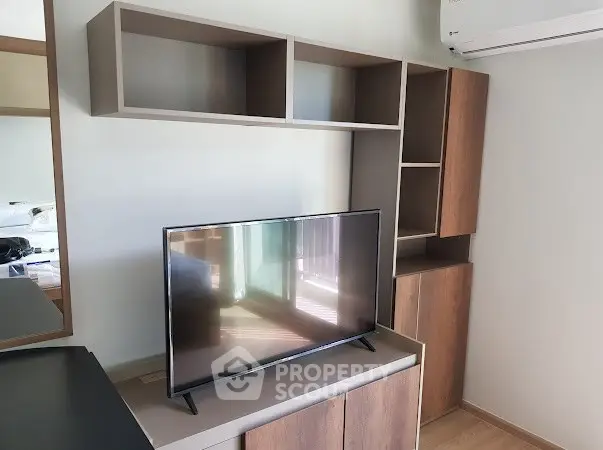 Modern living room with sleek TV stand and wall-mounted storage units.