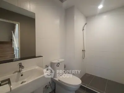 Modern bathroom with sleek fixtures and walk-in shower in contemporary home.