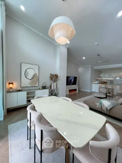 Elegant open-plan living and dining area with modern decor and stylish lighting.