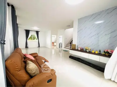 Spacious living room with modern decor and elegant staircase