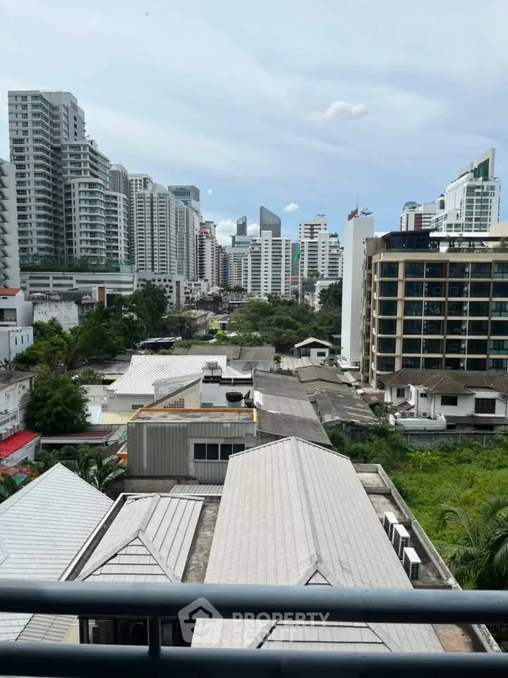 Stunning urban skyline view from a high-rise balcony, showcasing modern cityscape and lush greenery.