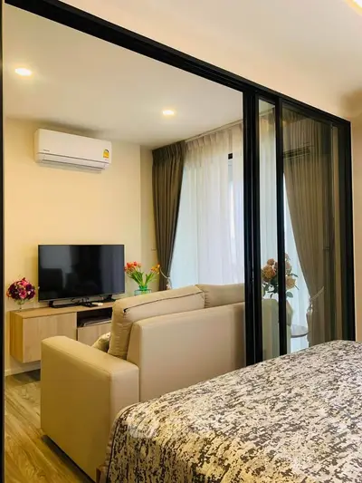 Modern living room with glass partition, cozy sofa, and stylish decor in a contemporary apartment.