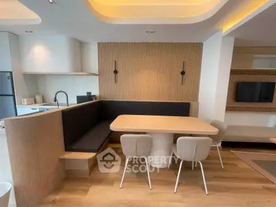 Modern dining area with stylish seating and wooden accents in open-plan living space.
