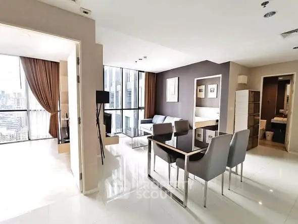 Modern open-plan living room with city view, sleek furniture, and elegant decor in high-rise apartment.