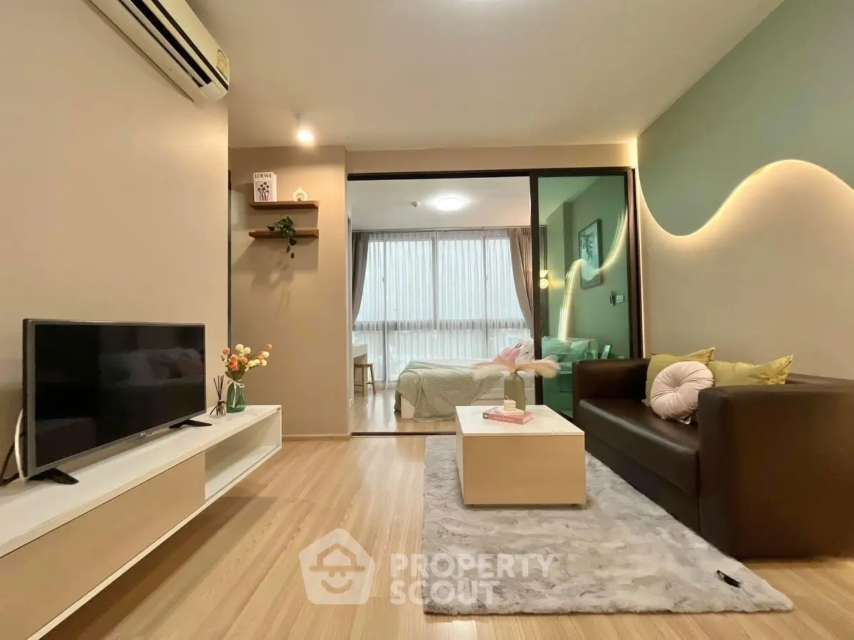 Modern living room with cozy decor and open layout leading to bedroom.