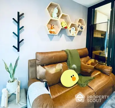 Cozy living room corner with a stylish brown leather sofa, adorned with a cute yellow cushion and a green throw, complemented by unique hexagonal wall shelves displaying charming figurines.