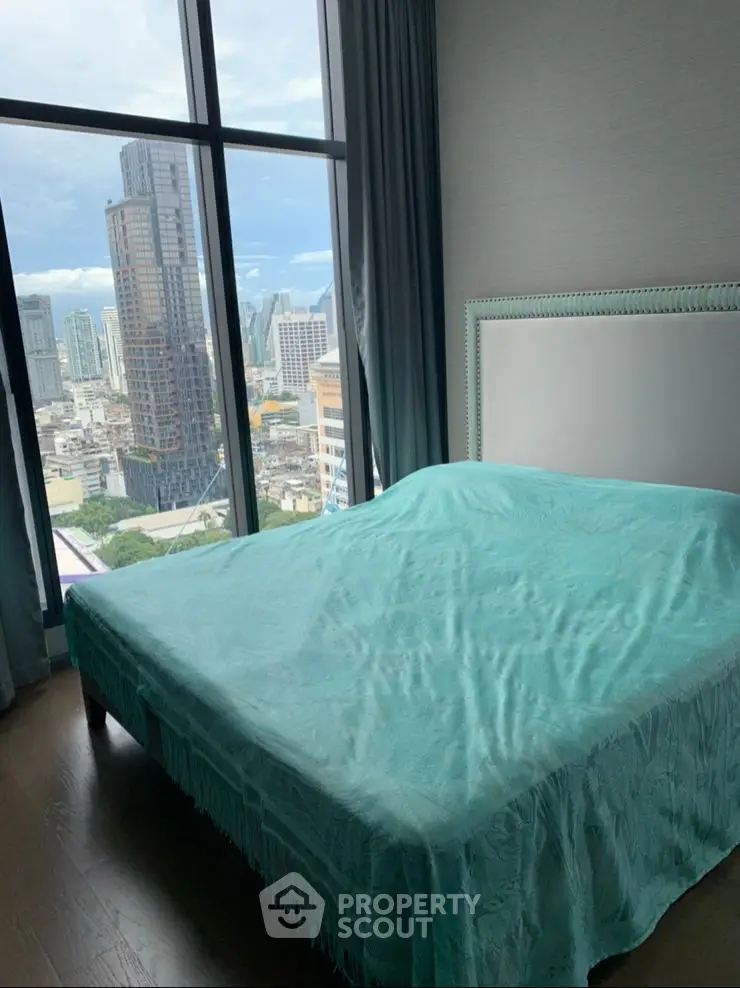 Modern bedroom with stunning city view through floor-to-ceiling windows.