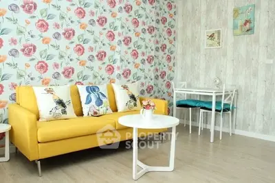 Charming living room with vibrant yellow sofa and floral wallpaper, perfect for cozy gatherings.