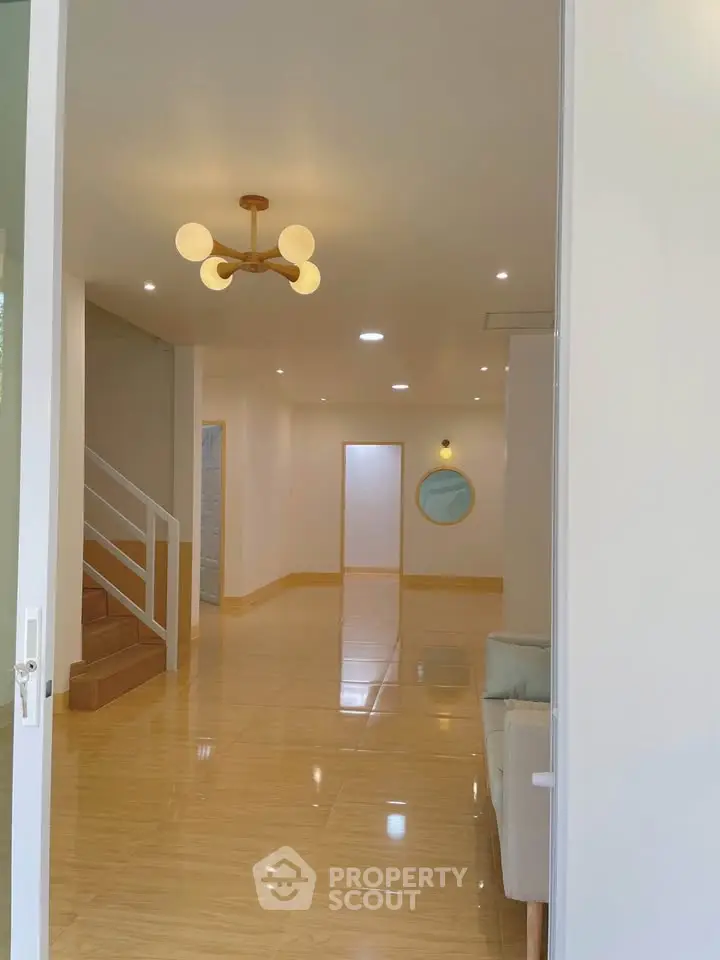 Spacious modern living room with elegant lighting and polished wooden flooring.