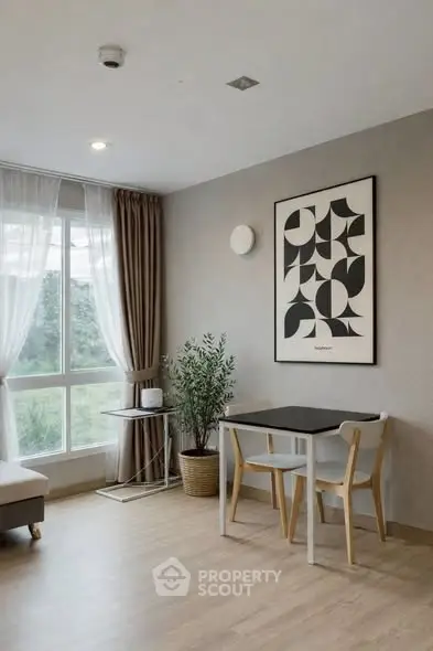 Modern living room with stylish decor and large window offering natural light.