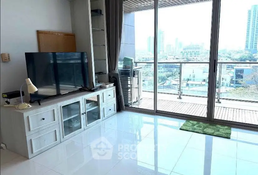 Modern living room with large TV and balcony view in high-rise apartment